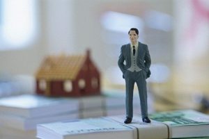 Businessman Figurine with Money and Model House